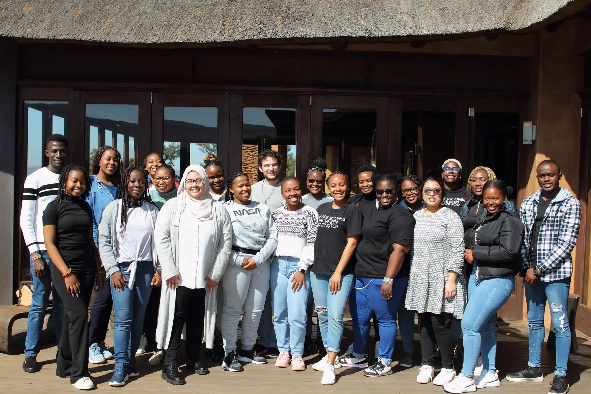 Cohort group photo outside a thatched venue