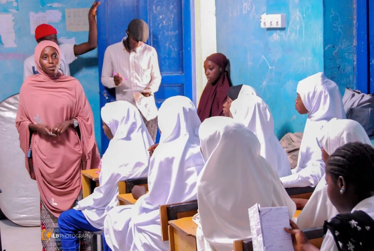Facilitator addressing schoolgirls seated in a classroom