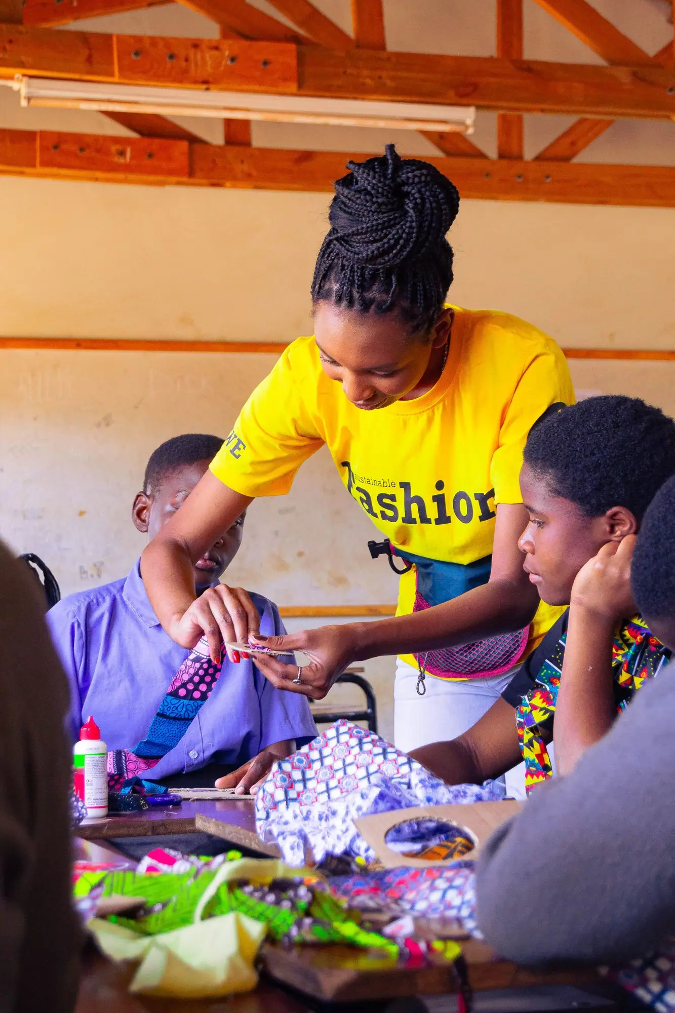 Facilitator helping a learner sew