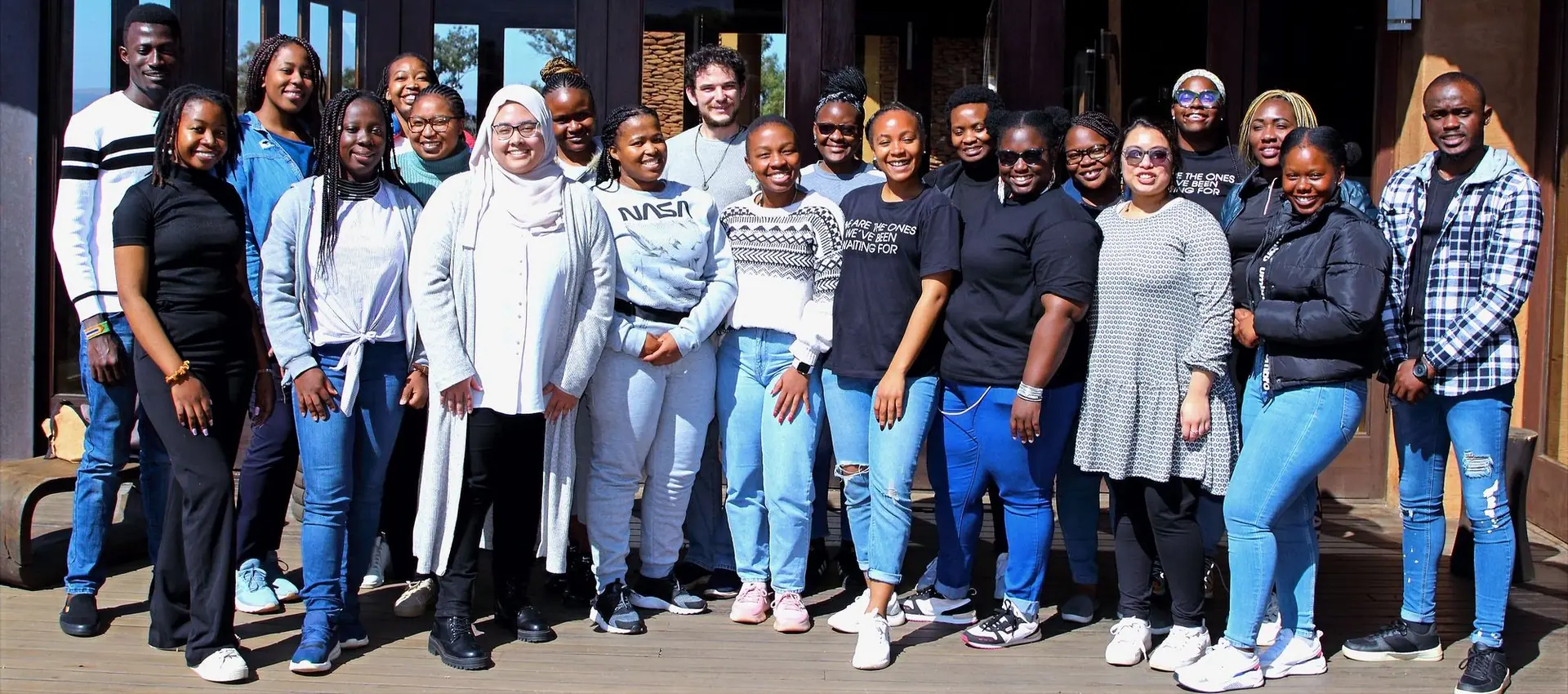 Large cohort group photo outdoors in branded T-shirts