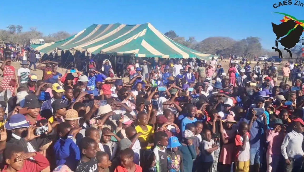 Large crowd gathered under a tent at a community event