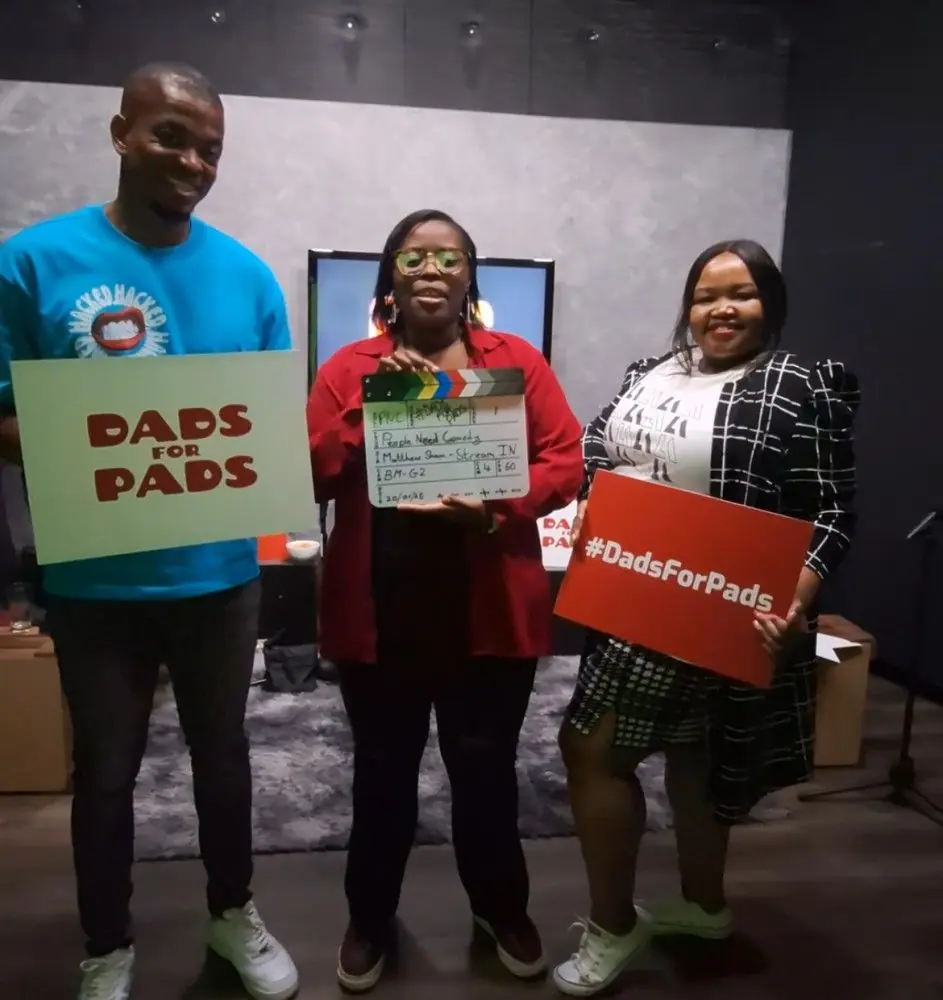 Participants holding Dads for Pads campaign signs