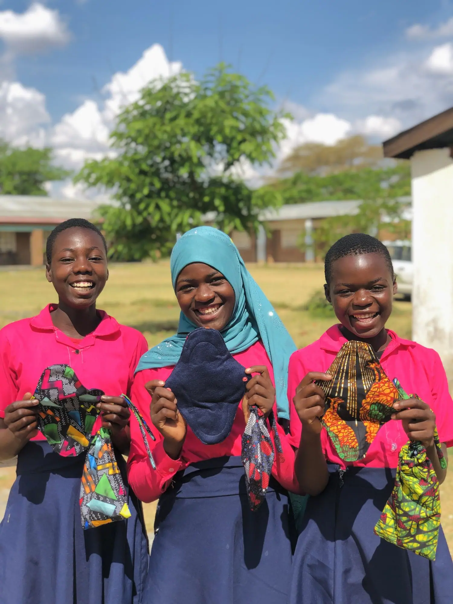 Schoolgirls holding the reusable pads they sewed