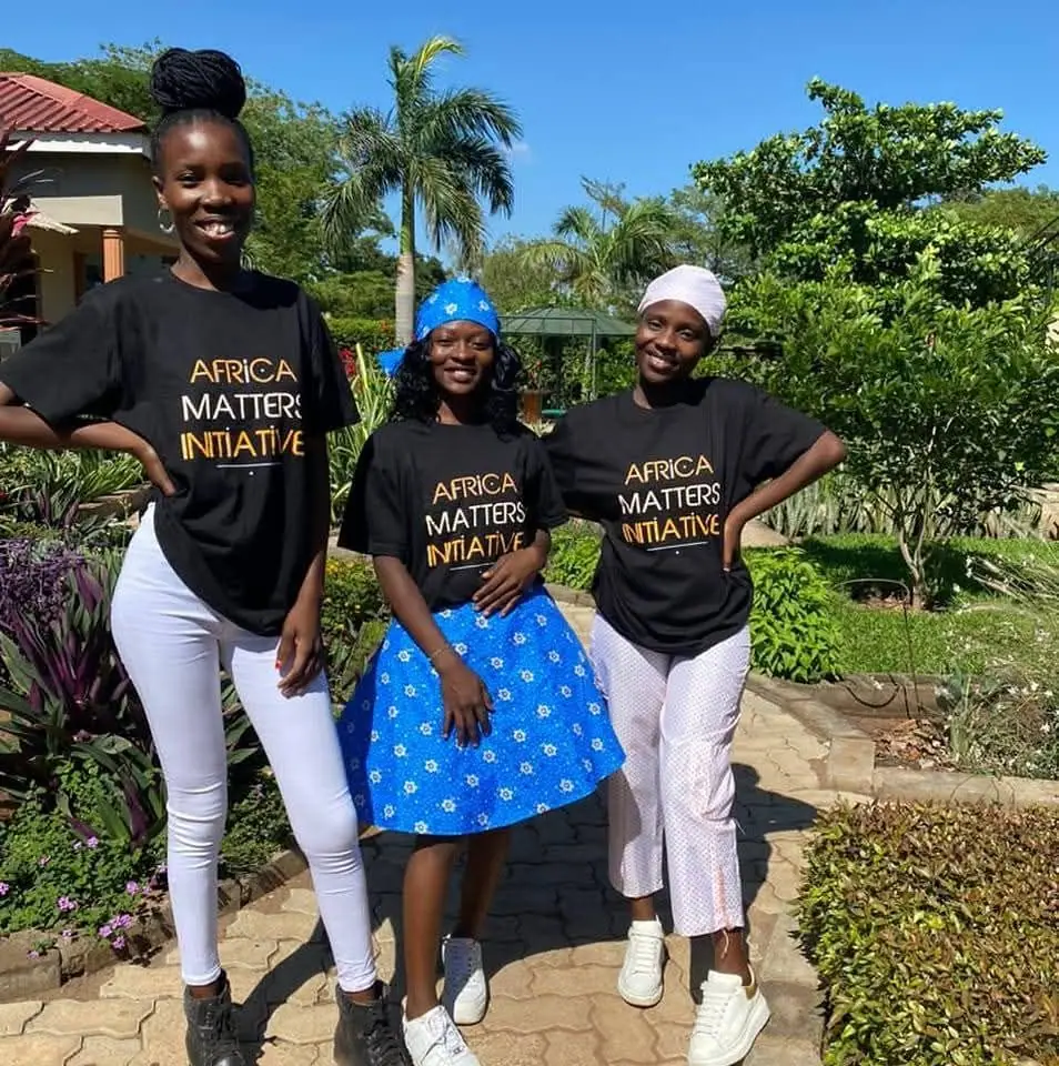 Three young women in Africa Matters Initiative T-shirts outdoors
