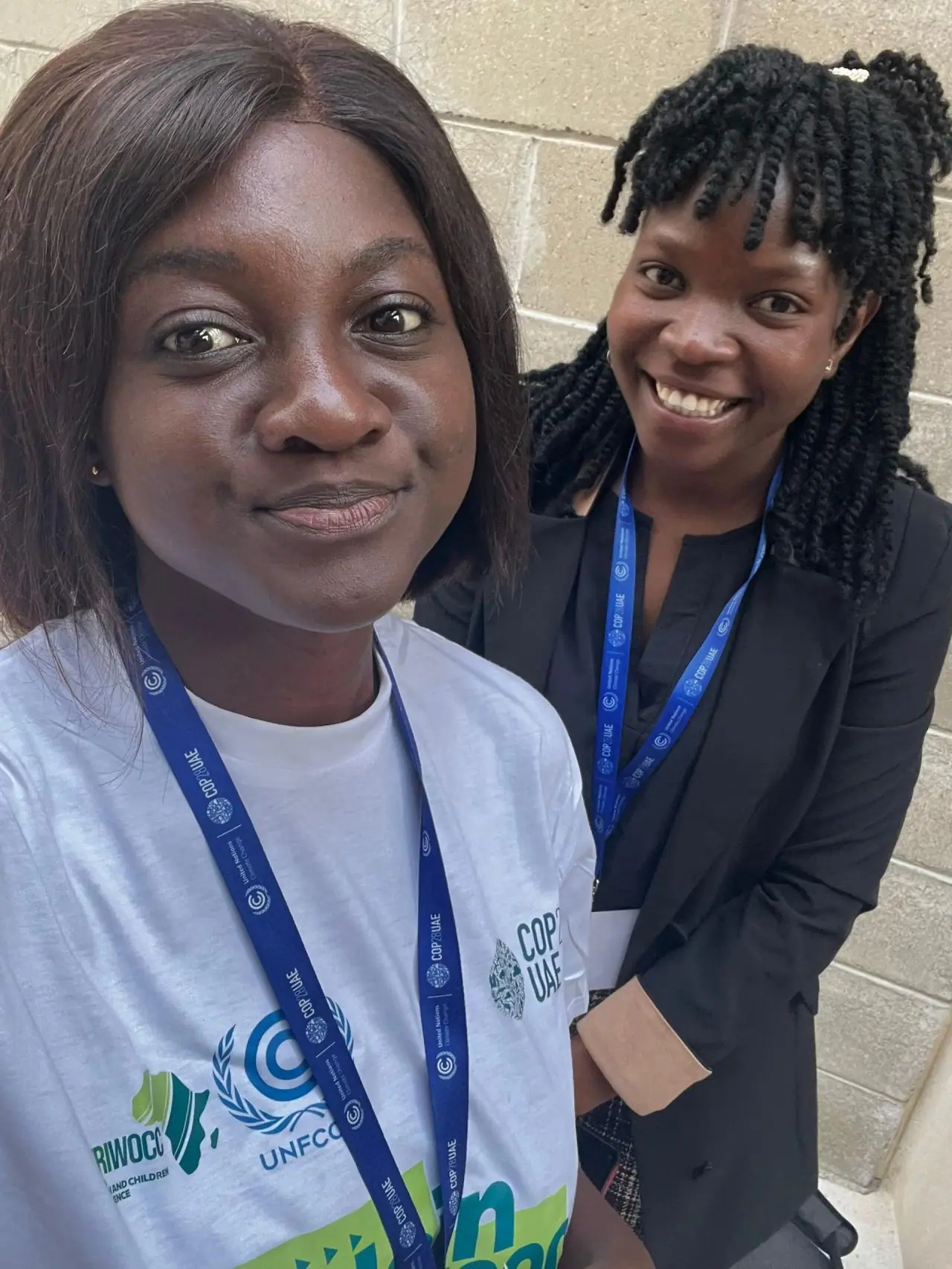 Two young women with conference lanyards taking a selfie