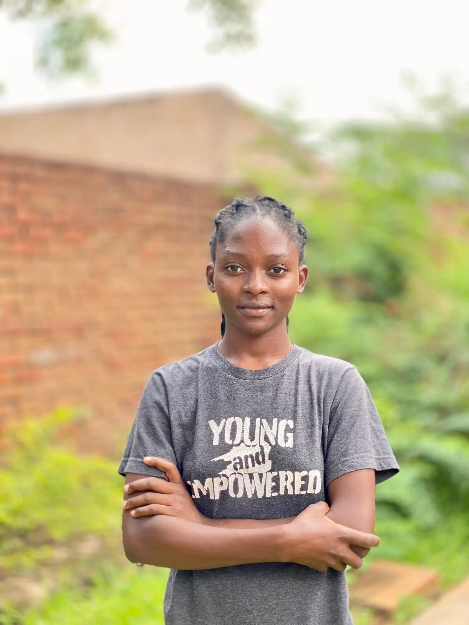 Young woman in a Young and Empowered T-shirt standing outdoors