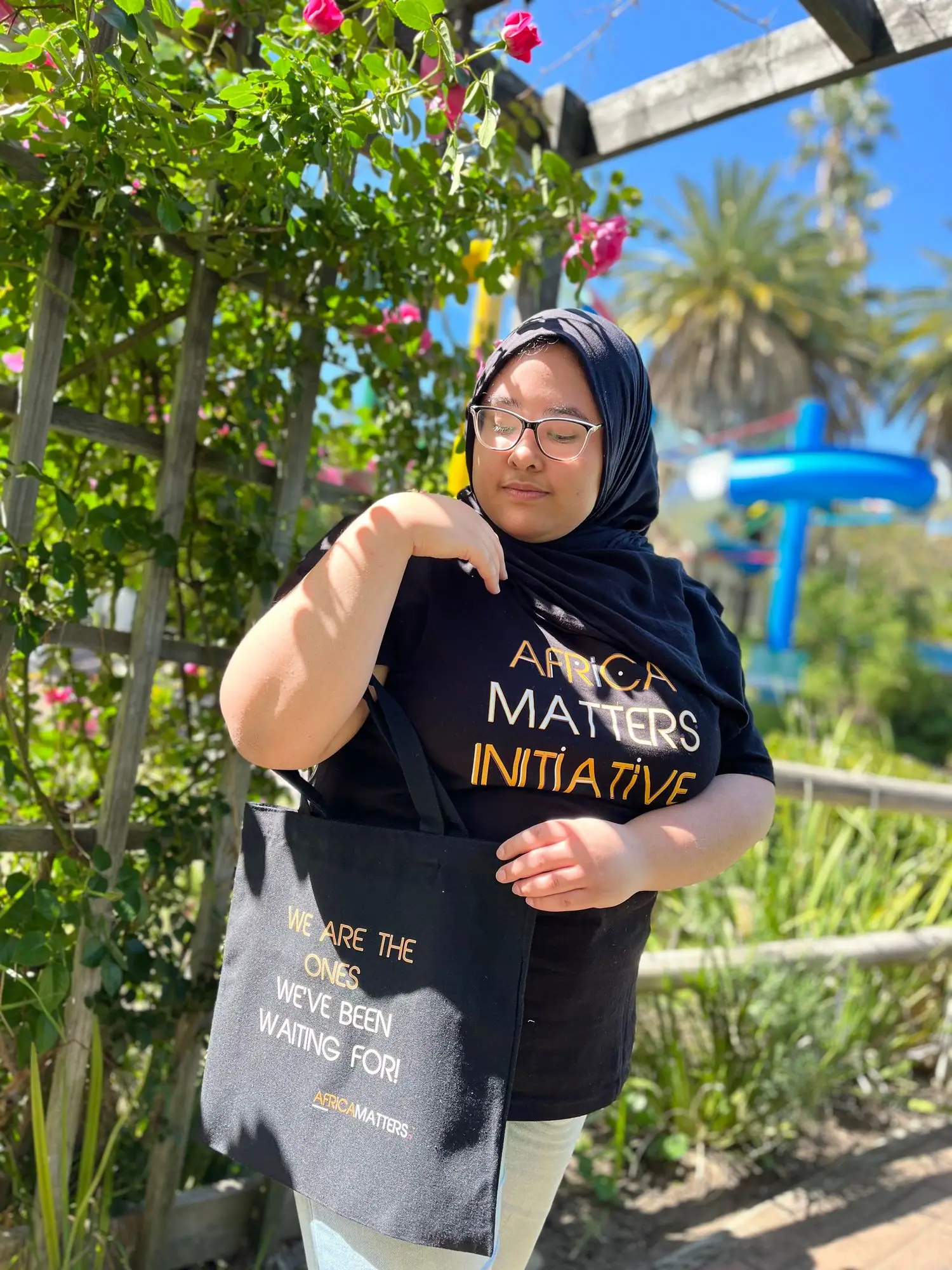 Young woman in an Africa Matters T-shirt holding a tote bag