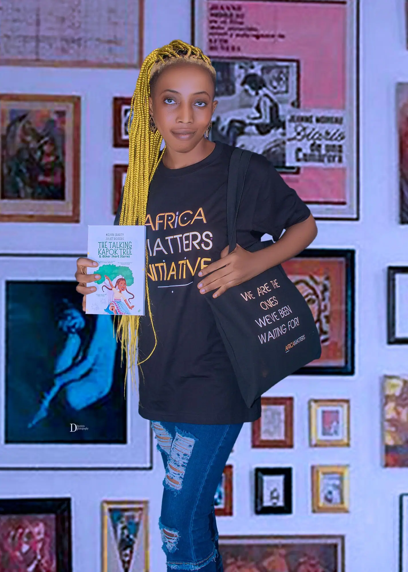 Young woman in an Africa Matters T-shirt in front of a gallery wall