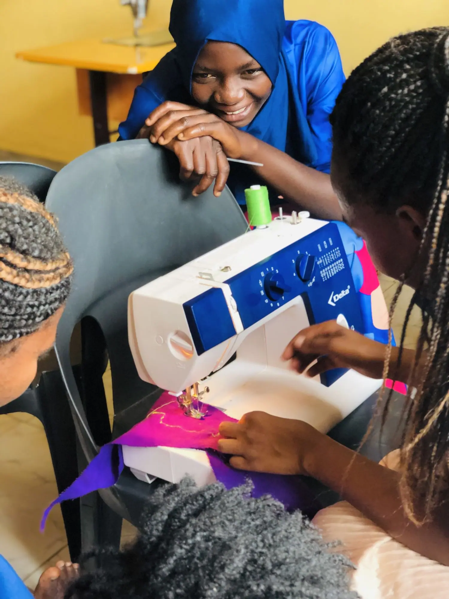 Young woman smiling at a sewing machine