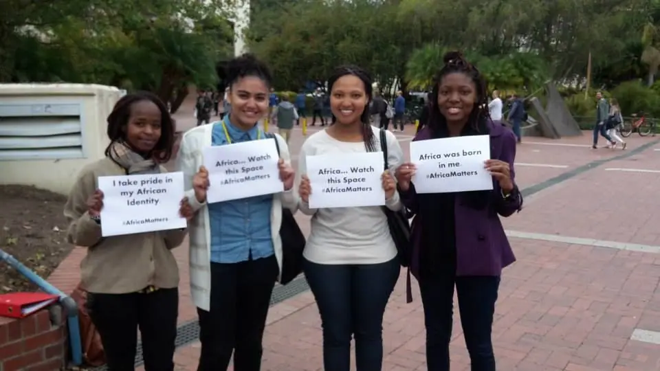 Young women holding handwritten message cards
